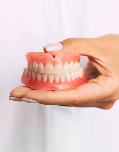 Close up of dentures in dentist’s hands