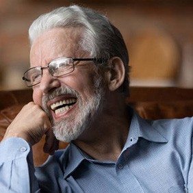 Laughing older man sitting in a leather chair