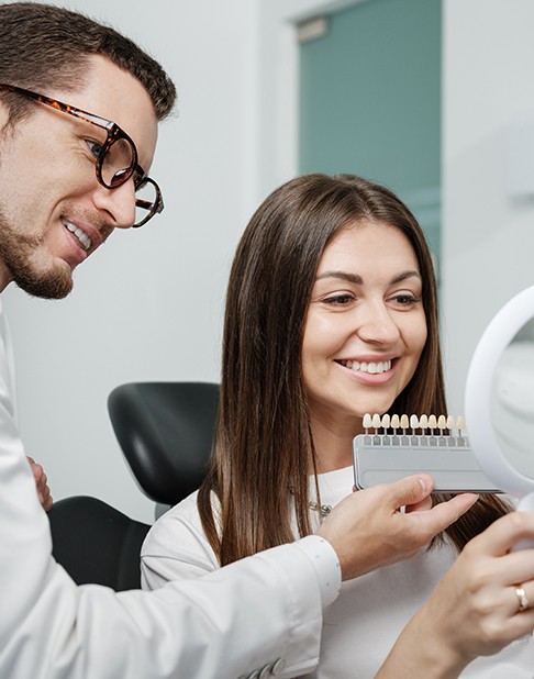 Dentist using a shade guide to determine veneer color