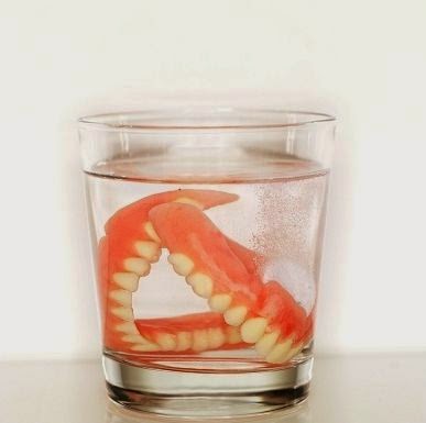 set of dentures in glass of water